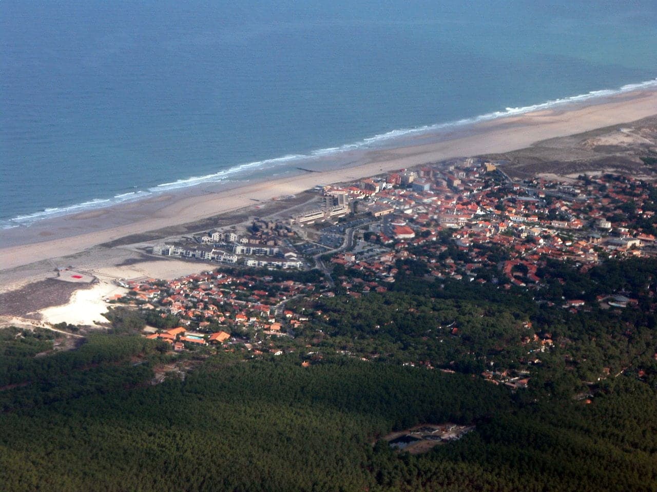 Vue aérienne de Lacanau-Océan : plage, océan Atlantique et forêt autour des habitations.
